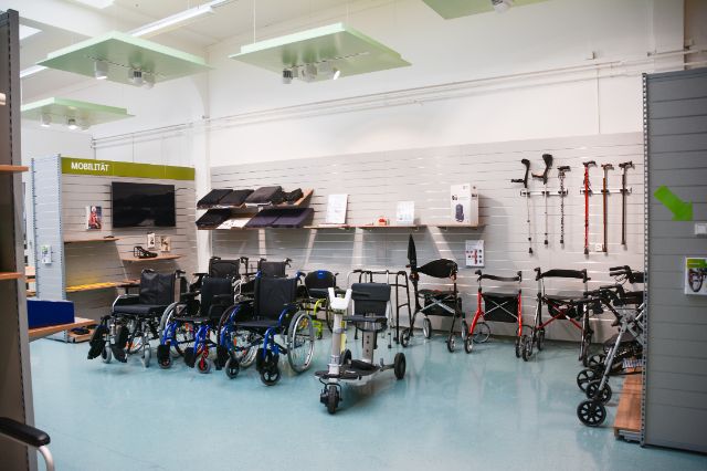 Ausstellungsraum zur Mobilität mit Gehhilfen, Rollstühlen und Sitzkissen.