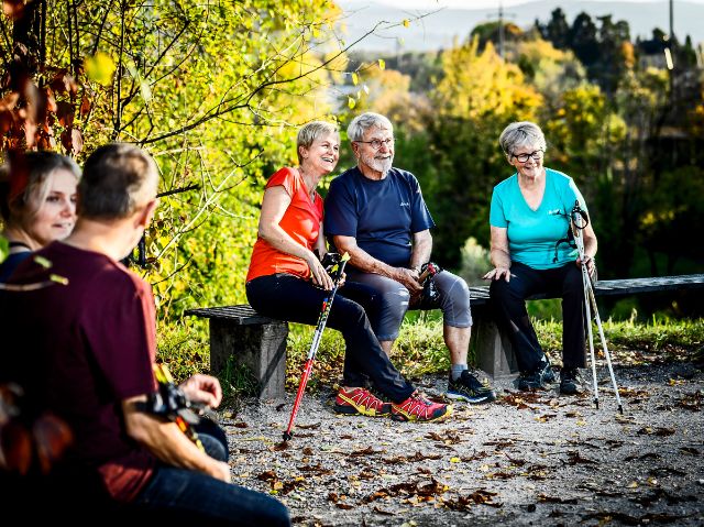 Die Teilnehmenden des Kurses Nordic Walking legen auf einer Lichtung einen Rast ein.